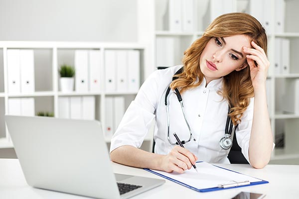 Stressed woman doctor thinking
